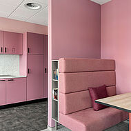  Rosafarbene Sitzbank und Rückwand in einem modernen Büroaufenthaltsraum